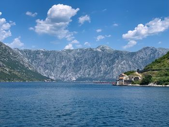 Scenic view of sea by mountains against sky