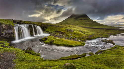 Scenic view of waterfall against sky