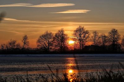 Scenic view of lake against orange sky