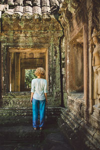 Rear view of woman standing in abandoned building