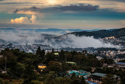 Downtown city view with dramatic cloudy sky at evening from mountain top