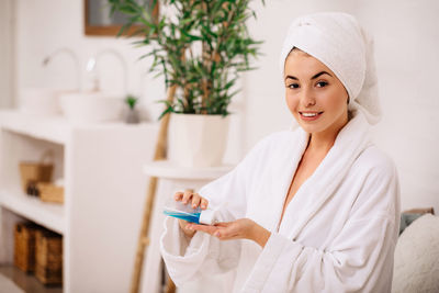 Portrait of smiling young woman standing at home