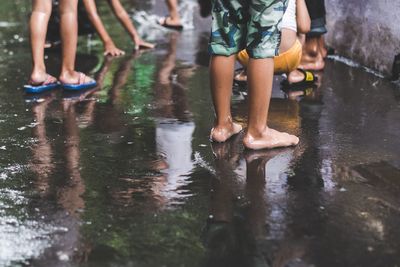 Low section of kids playing on wet street