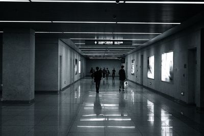 People walking in illuminated corridor