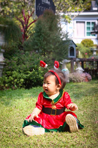 Portrait of cute girl sitting on field