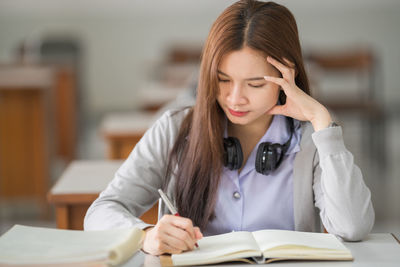 Portrait of girl sitting on book