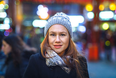 Portrait of happy woman in city at night
