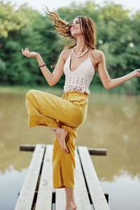 Portrait of young woman sitting on railing