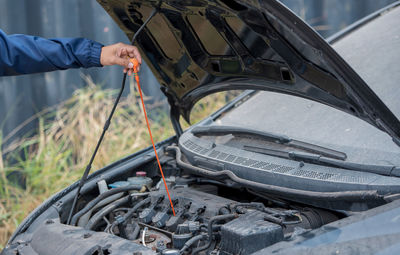 Midsection of man holding car