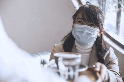 Asia woman take cup coffee from waitress holding and serving hot coffee in cafe shop