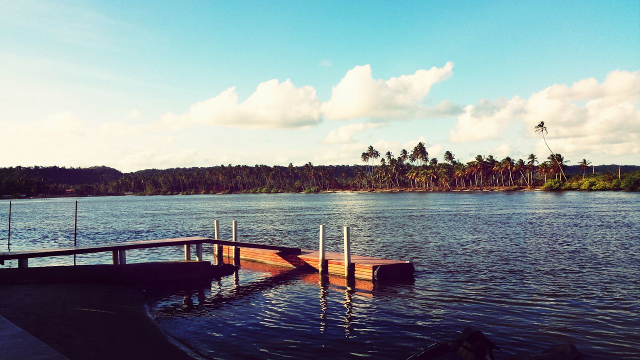 water, sky, built structure, river, cloud - sky, railing, pier, architecture, nature, tree, lake, tranquility, rippled, tranquil scene, beauty in nature, cloud, scenics, sea, building exterior, silhouette