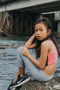 Portrait of young woman sitting outdoors