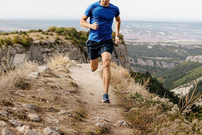 Low section of man running on hill