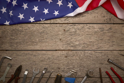 Directly above shot of american flag and work tools on wooden table