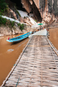 Boat moored on rock by river