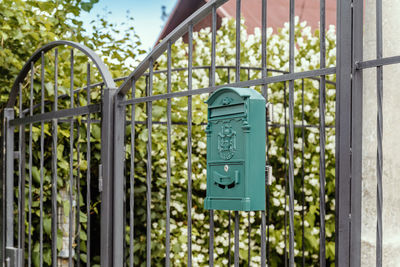 Green mailbox on metal grate