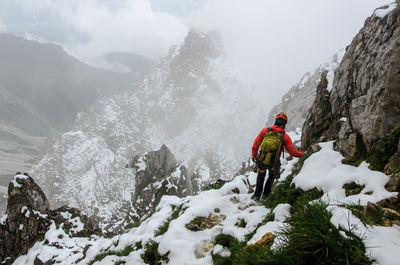 People hiking on snow covered mountain