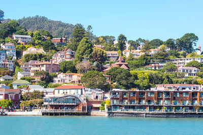 High angle view of townscape by river against sky