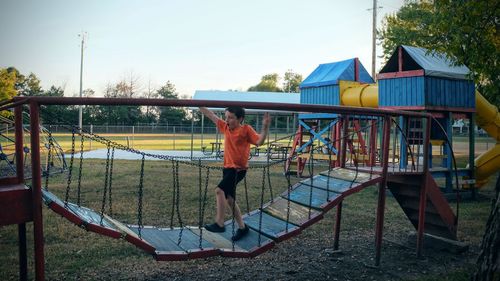 Boy walking on jungle gym in park