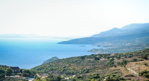 Scenic view of sea and mountains against clear sky