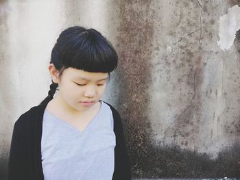 Girl looking at camera against wall