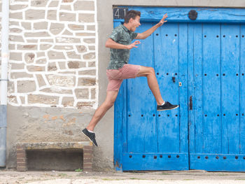 Full length of young woman standing against wall