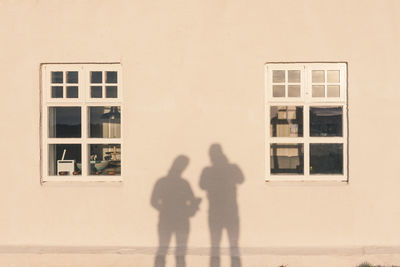Shadow of man standing on window