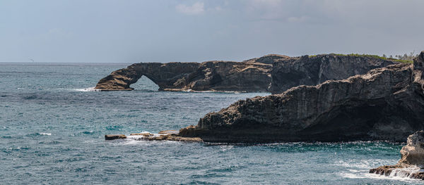 Panoramic view of rugged rocky ocean coastline with natural arch