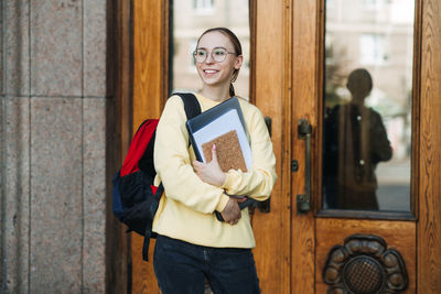 Mixed race college student girl enters the doors of the university, college.