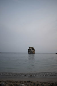 Scenic view of rocks in sea against sky