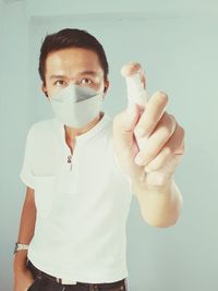 Portrait of young man standing against white background