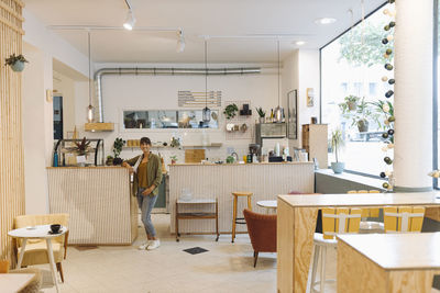 Businesswoman standing near counter in cafe