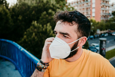 Portrait of young man drinking glass outdoors
