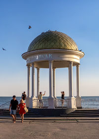 People at seaside against clear sky