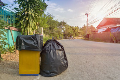 Garbage bin by street against buildings in city