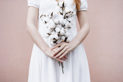 Midsection of woman standing against white background