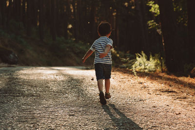 Rear view of man running on footpath