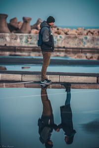 Reflection of man standing in swimming pool