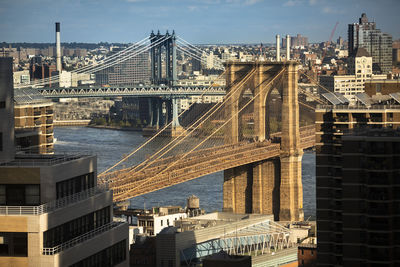 Bridge over river against buildings in city