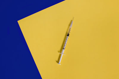 High angle view of pen against yellow background