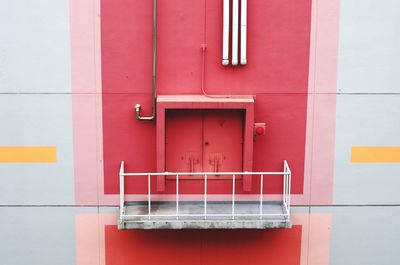 Closed red door and balcony of building