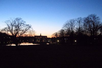 Silhouette bare trees against clear sky at sunset