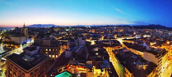 High angle view of illuminated cityscape against sky at dusk