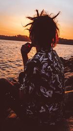 Rear view of woman at beach during sunset