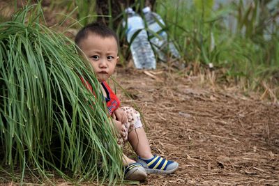 Portrait of smiling boy sitting on field