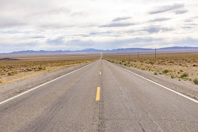 Road amidst field against sky