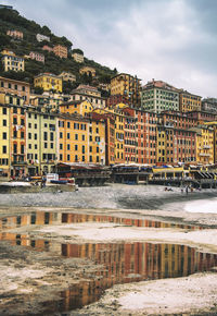 Buildings by river against sky in city