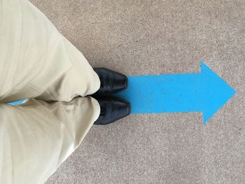 Low section of man standing on road