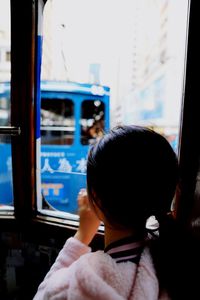 High angle view of girl looking through bus window