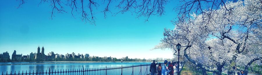 View of city at waterfront against blue sky